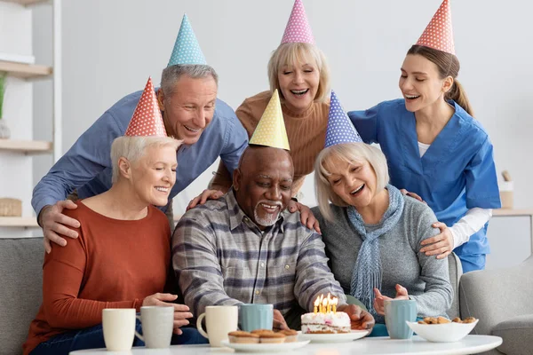 Starší černošky muž má narozeninový večírek v pečovatelském domě — Stock fotografie