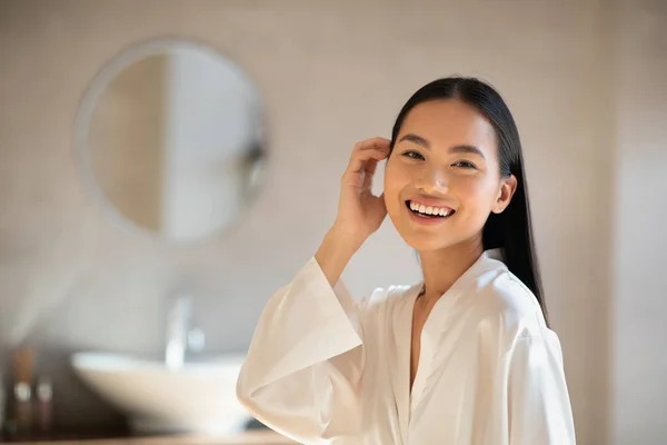 Positivo atraente senhora japonesa posando no banheiro moderno — Fotografia de Stock