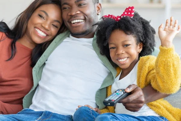 幸せな若い黒人の両親と彼らの小さな娘は自宅でテレビを見て — ストック写真