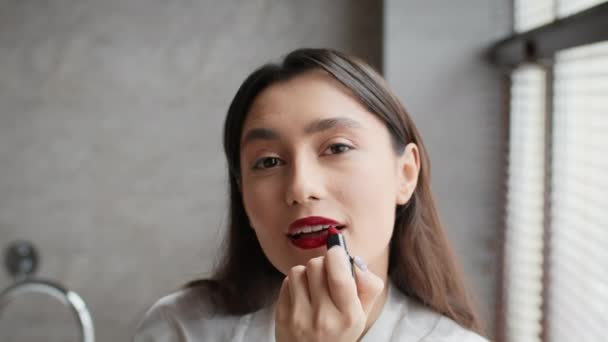 Atractiva morena dama aplicando brillante lápiz labial hacer maquillaje en el baño — Vídeo de stock