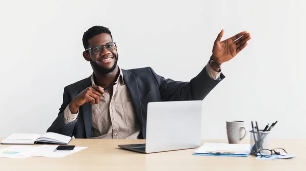 Jovem empreendedor negro feliz no desgaste formal usando laptop, gestos, demonstrando algo, fazendo apresentação — Fotografia de Stock