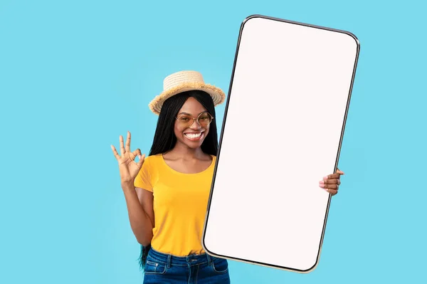 Веселая дама показывает большой белый пустой экран смартфона и хорошо — стоковое фото