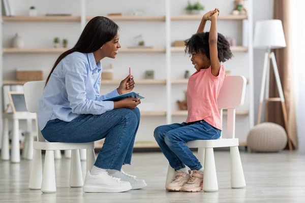 Захватывающая маленькая черная девочка в офисе детского психолога — стоковое фото