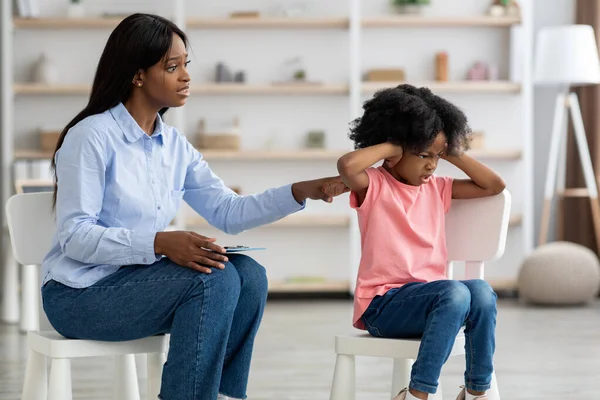 Mulher negra preocupada psicoterapeuta conversando com a menina indisciplinada — Fotografia de Stock
