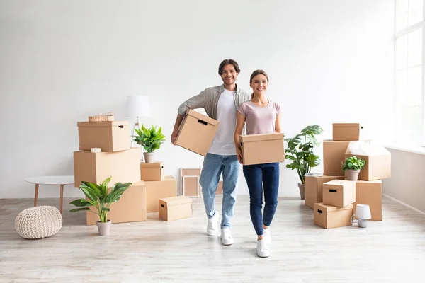 Feliz pareja joven europea en cajas de cartón casual llevar con cosas en la habitación y disfrutar de la compra de nuevo apartamento —  Fotos de Stock