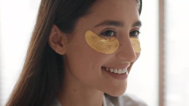 Happy Lady con parches aplicados debajo de los ojos hidratando la piel en interiores — Vídeos de Stock
