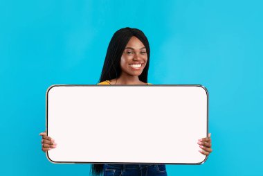 Neşeli siyah kadın büyük beyaz, boş akıllı telefon ekranı gösteriyor.