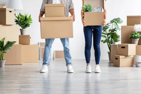 Esposa joven europea y marido en cajas de cartón casuales con pertenencias, mudándose a un nuevo hogar —  Fotos de Stock