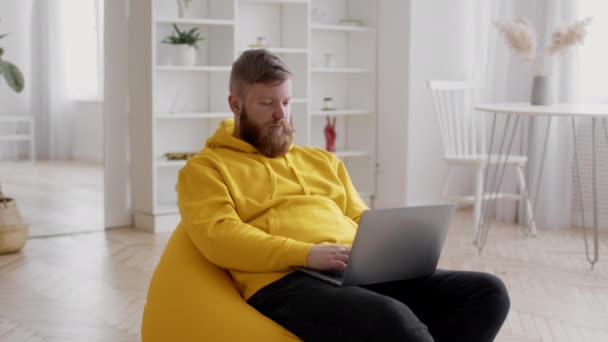 Freelancer Man met behulp van laptop werken online zitten thuis — Stockvideo
