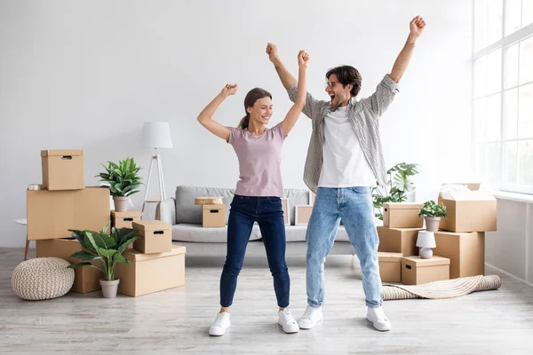 Satisfait millénariste européen gars et femme ont plaisir à danser dans la chambre intérieure parmi les boîtes, célébrer la maison de location — Photo