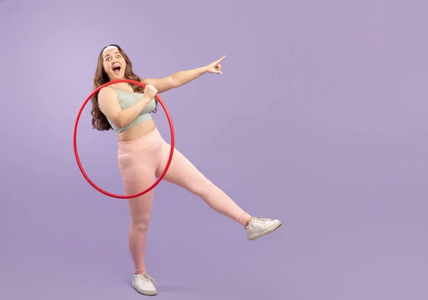 Zufriedene junge europäische Plus-Size-Hündin in Sportbekleidung mit offenem Mund hält Hula-Hoop-Reifen, hat Spaß — Stockfoto