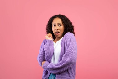 Genç siyahi kadın korkmuş hissediyor. Pembe stüdyo geçmişinde panik içinde bağırıyor.