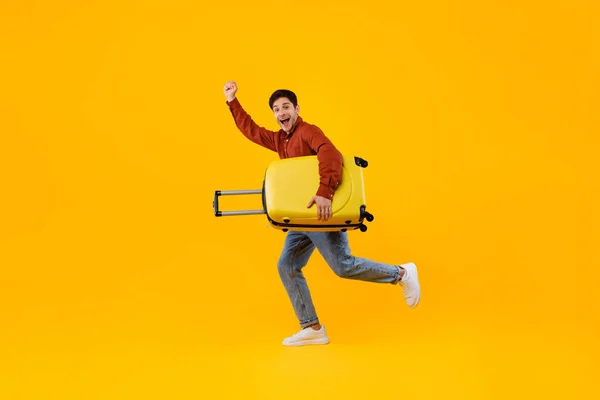 Щасливий Туристичний Чоловік Стрибки Тримає Валізу Жести Так, жовтий фон — стокове фото