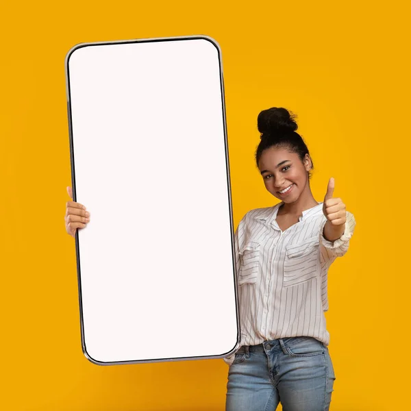 Preto menina mostrando grande branco vazio smartphone tela e como — Fotografia de Stock