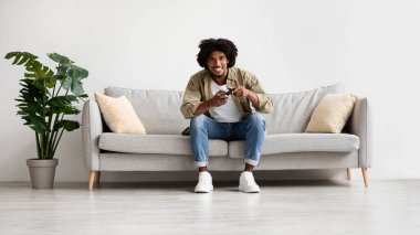 Yurt içi eğlence. Neşeli Siyah Milenyum Adamı Evde Video Oyunları Oynuyor