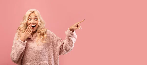 Sorpresa caucasico signora indicando dito a copiare spazio in piedi su sfondo rosa, riprese in studio, panorama — Foto Stock