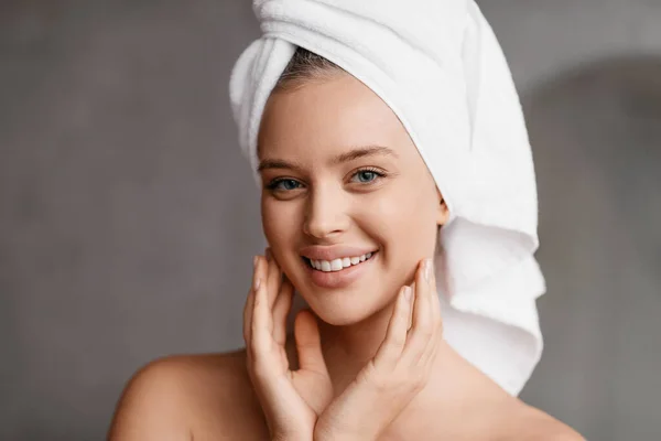 Happy lady pozowanie z ręcznikiem na głowie po rutynowych kąpieli, stojąc w nowoczesnej łazience i uśmiechając się do kamery — Zdjęcie stockowe