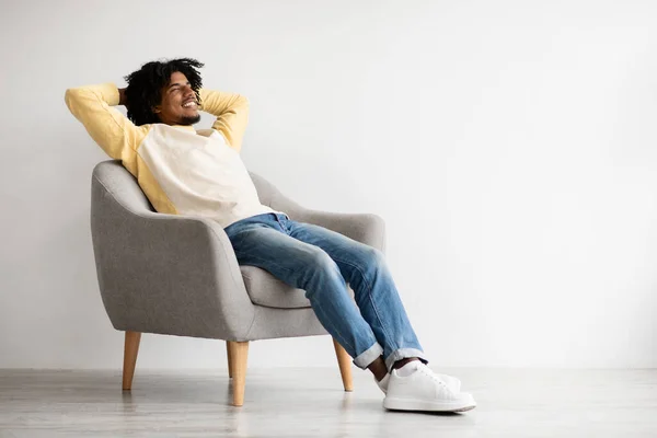 Ev içi rahatlık. Memlekette Kol Sandalyesinde Rahatlayan Mutlu Siyah Adam Portresi — Stok fotoğraf