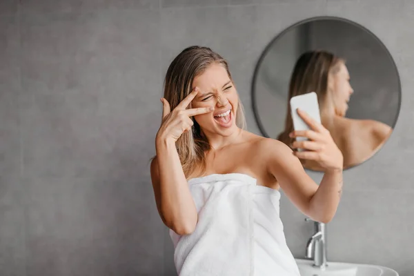 Παιχνιδιάρα γυναίκα που παίρνει selfie στο smartphone, ενώ απολαμβάνοντας την ομορφιά πρωινό ρουτίνα στο μπάνιο στο σπίτι — Φωτογραφία Αρχείου