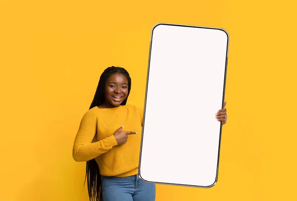 Emocionada dama negra apuntando a la pantalla blanca vacía del teléfono inteligente —  Fotos de Stock