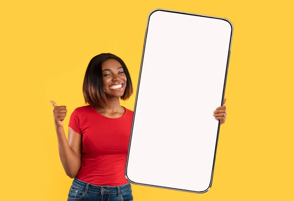 Schwarze Dame zeigt großen weißen leeren Smartphone-Bildschirm und gefällt — Stockfoto