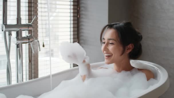 Senhora feliz tomando banho se divertindo soprando na espuma no banheiro — Vídeo de Stock