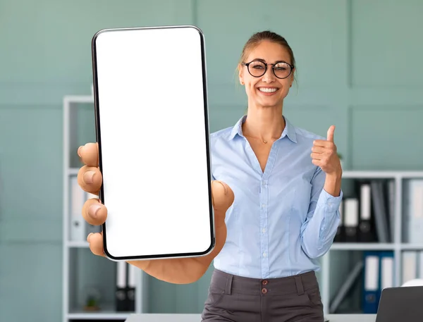 Attractive lady office manager showing smartphone with empty screen — Stock Photo, Image