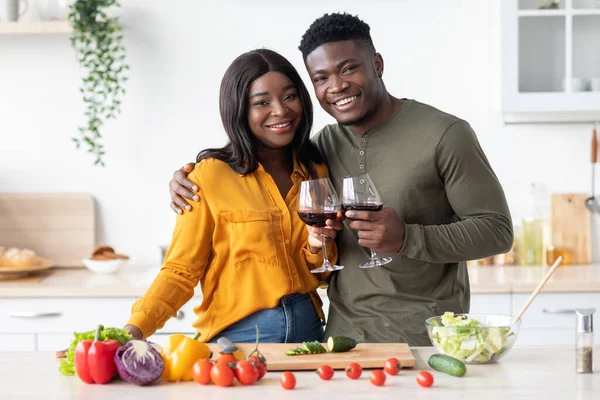 Retrato de feliz pareja negra romántica bebiendo vino y posando en la cocina — Foto de Stock