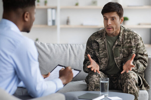 Emotional military man gesturing while talking to psychotherapist