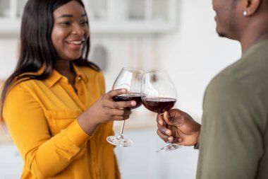 Aşka kadeh kaldıralım. Kırmızı şarapla kadeh tokuşturan romantik Afrikalı Amerikalı çift
