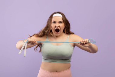 Kızgın, agresif, genç Avrupalı ve spor giyimli, ağzı açık, çığlık atan ve ip atlayan bir kadın.