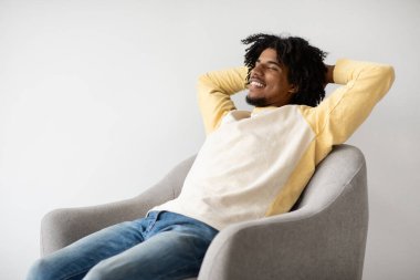 Hayat güzel. Kol Sandalyesinde Rahatlayan Genç Siyah Adam, Yakın plan