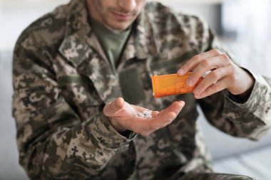 Kamuflaj üniformalı tanınmayan bir asker ilaç alıyor.