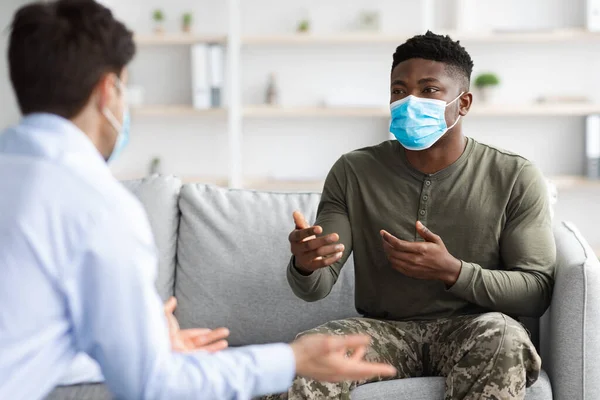 Soldado negro con mascarilla visitando psicólogo mientras pandemia —  Fotos de Stock
