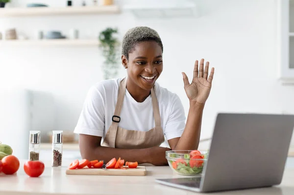 웰던 밀레니엄 아프리카 계 미국인 여성 이 주방에서 노트북으로 손을 흔들고 있는 모습 — 스톡 사진