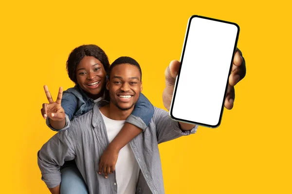 훌륭 한 모바일 앱입니다. 사랑하는 흑인 커플 이 스마트폰을 흉내내어 복사 공간을 제공하고 웹 사이트, 광고 앱을 홍보하고 있습니다. — 스톡 사진