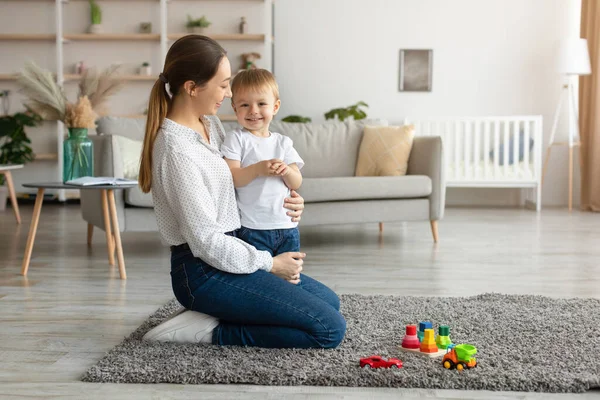 Moederschap concept. Portret van de jonge moeder met peuter zoon samen tijd doorbrengen thuis, vrije ruimte — Stockfoto