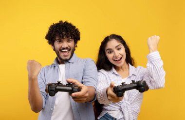 Boş zaman eğlence konsepti. Oyun oynayan Hintli çift ellerinde joysticklerle oyun oynuyorlar.