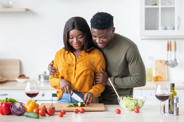 Romántico joven negro pareja cocina almuerzo en cocina y beber vino tinto — Foto de Stock