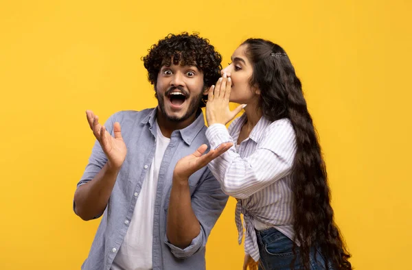 Jovem indiana compartilhando segredos com seu namorado animado, casal milenar sussurrando fofocas uns com os outros — Fotografia de Stock