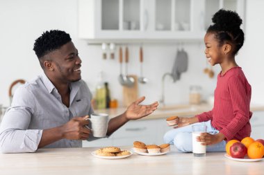 Neşeli baba ve çocuk çerez yerken konuşuyor