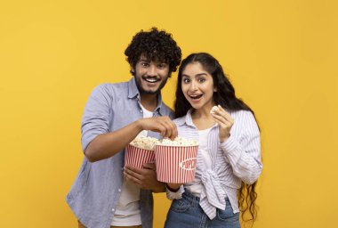 İnanılmaz bir eğlence, birlikte boş zaman geçirmek. Şaşırmış Hintli adam ve kadın patlamış mısır yiyor ve film izliyorlar.