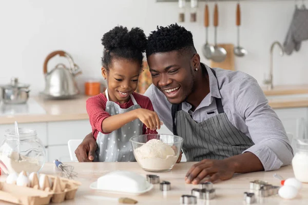 Radosny czarny ojciec i córka pieką razem w domu — Zdjęcie stockowe