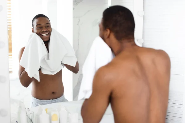 Buenos días Rutina. Feliz negro sin camisa joven limpiando la cara con toalla — Foto de Stock