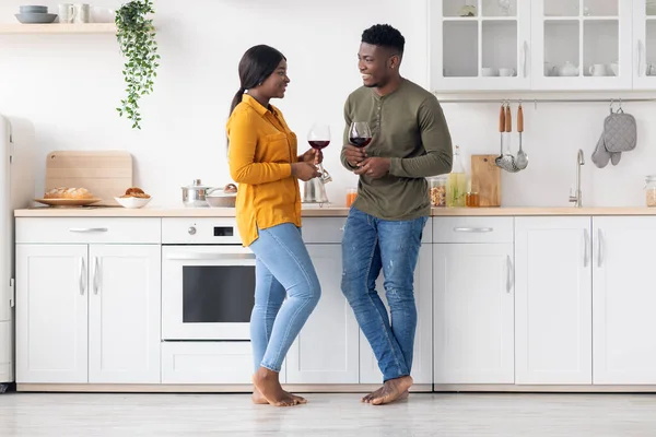 Heureux couple afro-américain romantique boire du vin et bavarder ensemble dans la cuisine — Photo