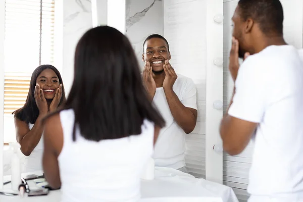 Concepto de cuidado de belleza. Feliz pareja negra haciendo rutina de la mañana en el baño — Foto de Stock