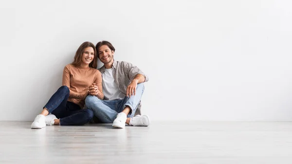 Nöjd tusenårig europeisk man och dam håller hand, planerar framtida interiör — Stockfoto