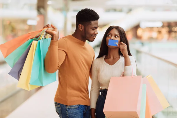 Retrato de señora negra feliz mostrando tarjeta de crédito al hombre —  Fotos de Stock