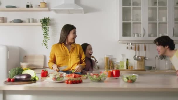 Feliz rotina familiar. Jovem mulher asiática cozinhar na cozinha, seu marido e filha correndo, jogando catch-up — Vídeo de Stock