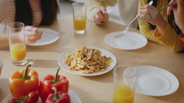 Pranzo di famiglia. Primo piano di genitori e bambini che si godono la cena insieme a casa, condividono un piatto di spaghetti, tracciano lo sparo — Video Stock